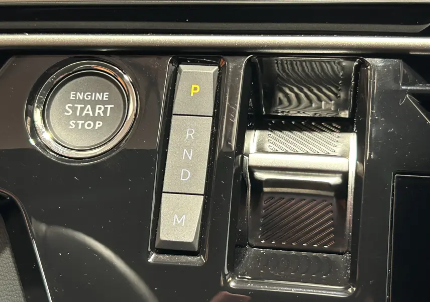 Gros plan sur la console centrale du Peugeot 3008 III Hybrid avec bouton start/stop et commandes de boîte automatique.