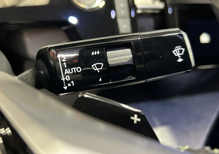 Gros plan sur la commande de l’essuie-glace noir brillant dans l’habitacle du Peugeot 3008 Hybrid 2025.