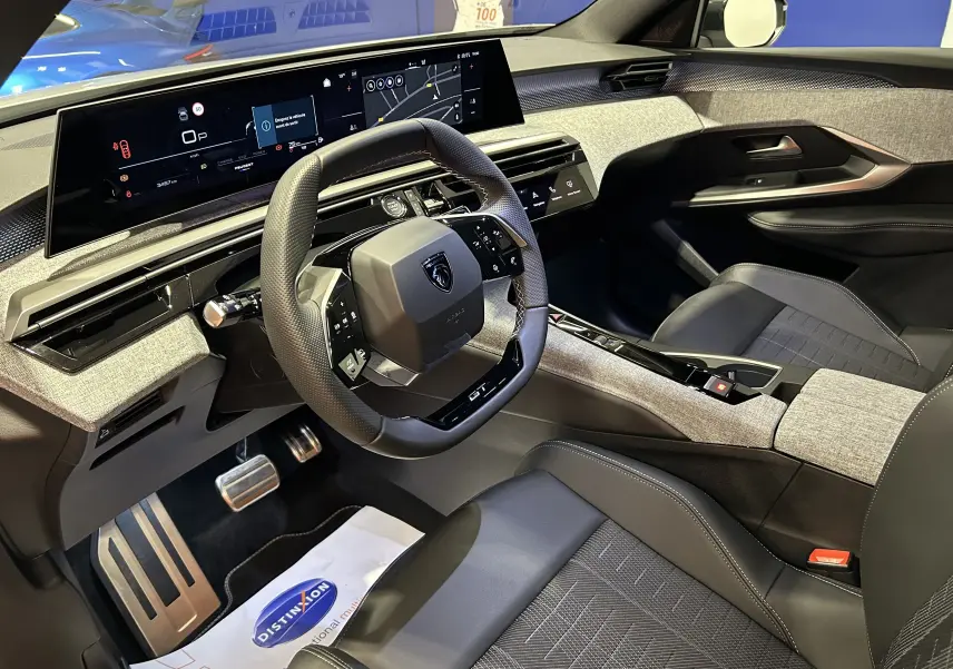 Vue intérieure côté conducteur du Peugeot 3008 Hybrid avec tableau de bord numérique et finitions grises et noires.