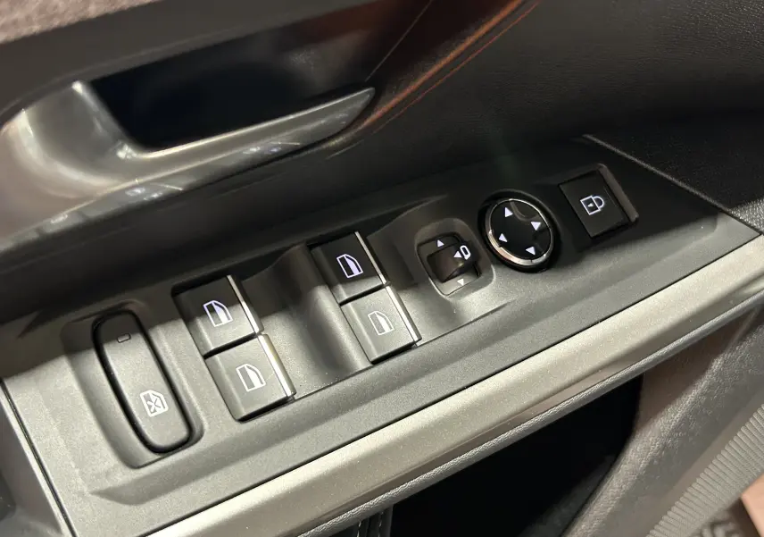 Gros plan sur les commandes de lève-vitres et rétroviseurs côté conducteur du Peugeot 3008 blanc Okenite, intérieur noir.