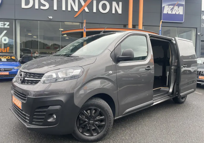 Opel Vivaro Fourgon gris Pierre de Lune métallisé vu de 3/4 avant droit avec porte latérale coulissante ouverte.