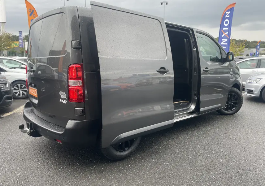 Opel Vivaro Fourgon gris Pierre de Lune métallisé vu de 3/4 arrière droit, porte coulissante ouverte et jantes noires.
