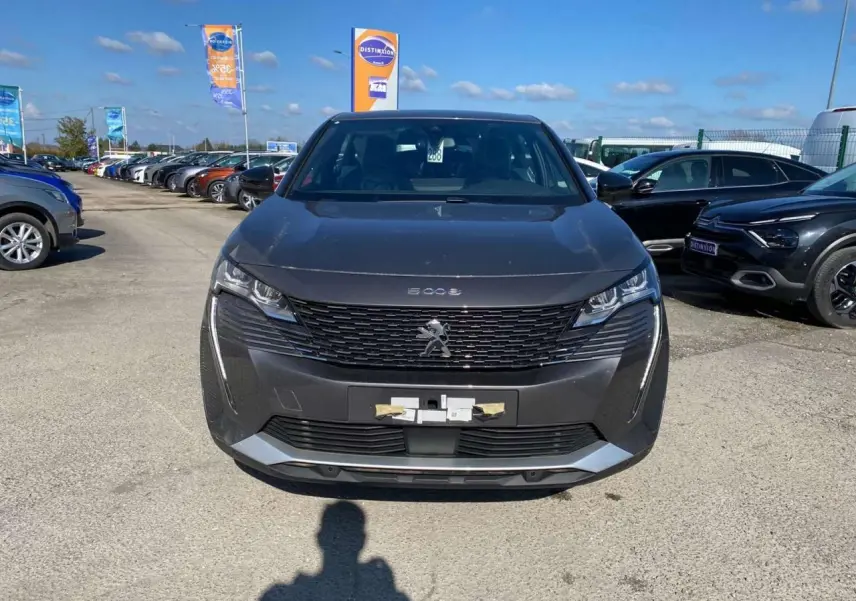 Vue avant du Peugeot 5008 gris platinium métallisé 2023 avec calandre noire et feux LED distinctifs.