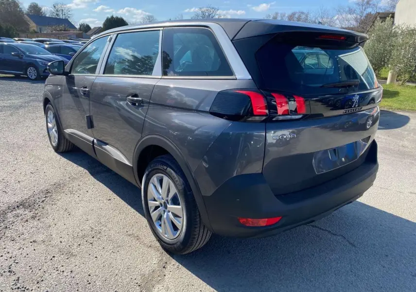 Vue 3/4 arrière droit du Peugeot 5008 gris platinium métallisé avec feux arrière LED et jantes alliage 17 pouces.
