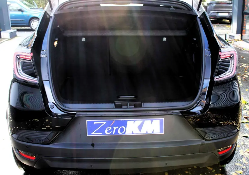 Vue arrière d'un Renault Captur noir métal avec coffre ouvert et toit gris visible en partie supérieure.