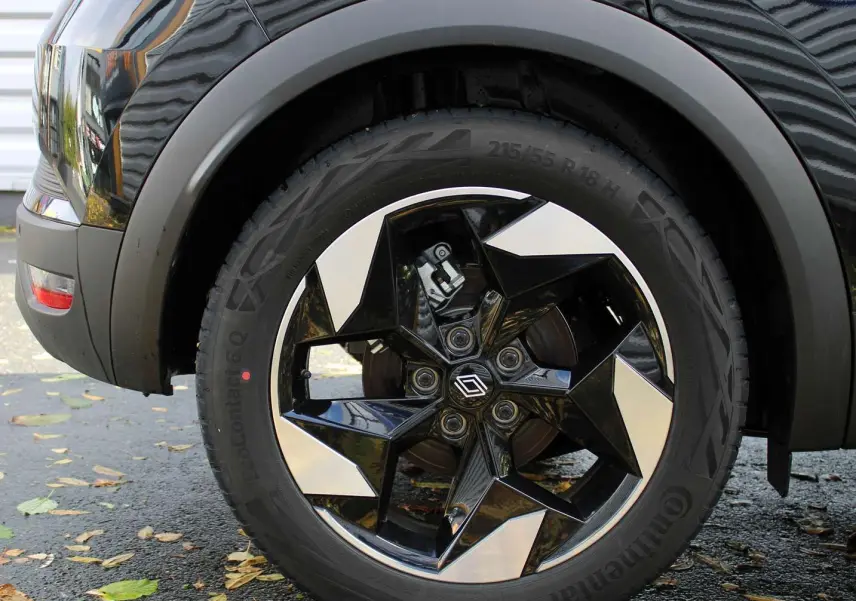 Gros plan sur la roue avant gauche du Renault Captur 2025 noir métal avec jante diamantée noire et argentée.
