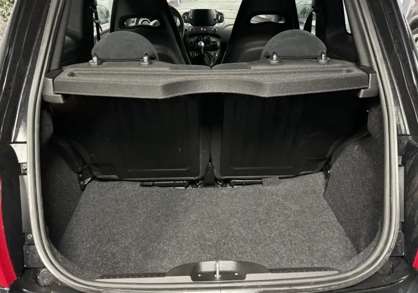Coffre ouvert vu de l'arrière de l'Abarth 595 Competizione noire, montrant les sièges arrière et la tablette cache-bagages.