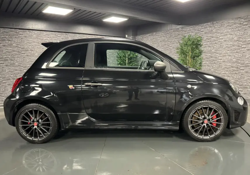 Profil côté gauche de l'Abarth 595 Competizione noire avec jantes alliage 17 pouces et étriers Brembo rouges.