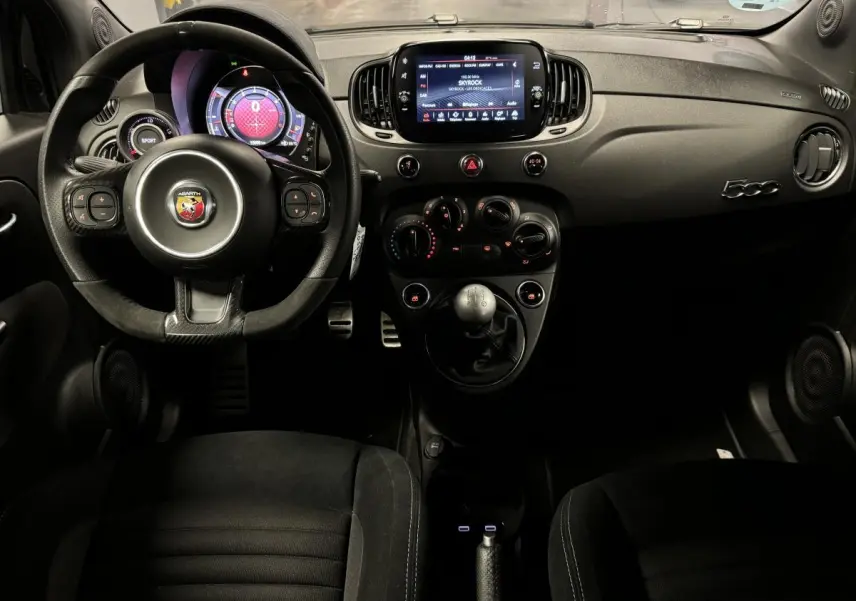 Intérieur de l'Abarth 595 Competizione 2022 vu de face, volant cuir/alcantara, écran tactile 7'', levier de vitesses manuel.