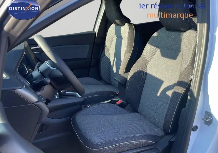 Intérieur du Renault Captur E-Tech 2025, vue côté gauche sur les sièges tissu noir et gris, porte blanche ouverte.