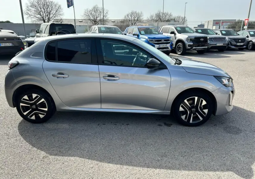 Peugeot 208 Hybrid 110 e-DCS6 Allure gris vue de profil côté gauche, avec jantes noires et argentées.
