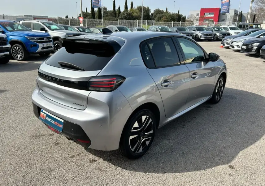 Vue 3/4 arrière droite d'une Peugeot 208 Hybrid 110 gris métallisé avec feux arrière LED et jantes alliage distinctives.