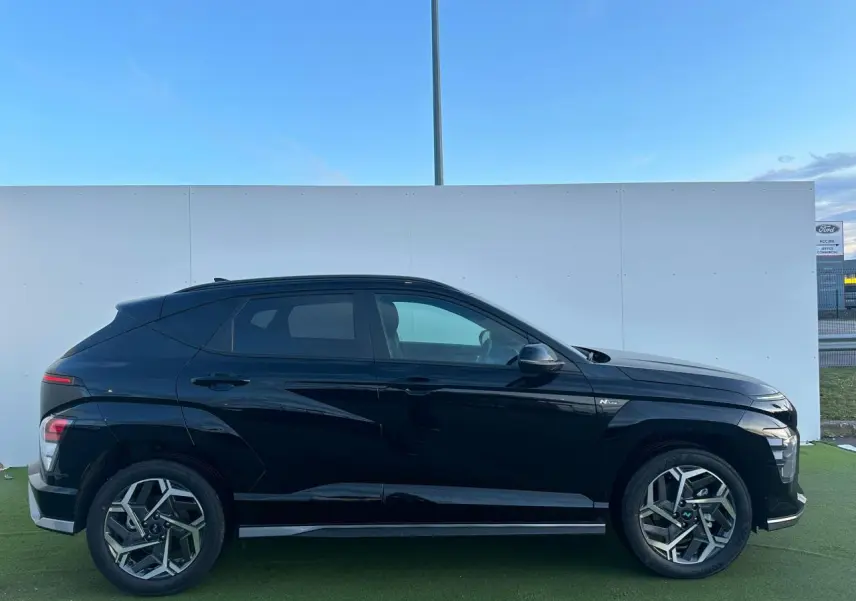 Vue latérale droite du Hyundai KONA II noir Abyss Metal avec jantes alliage 18 pouces et vitres surteintées.