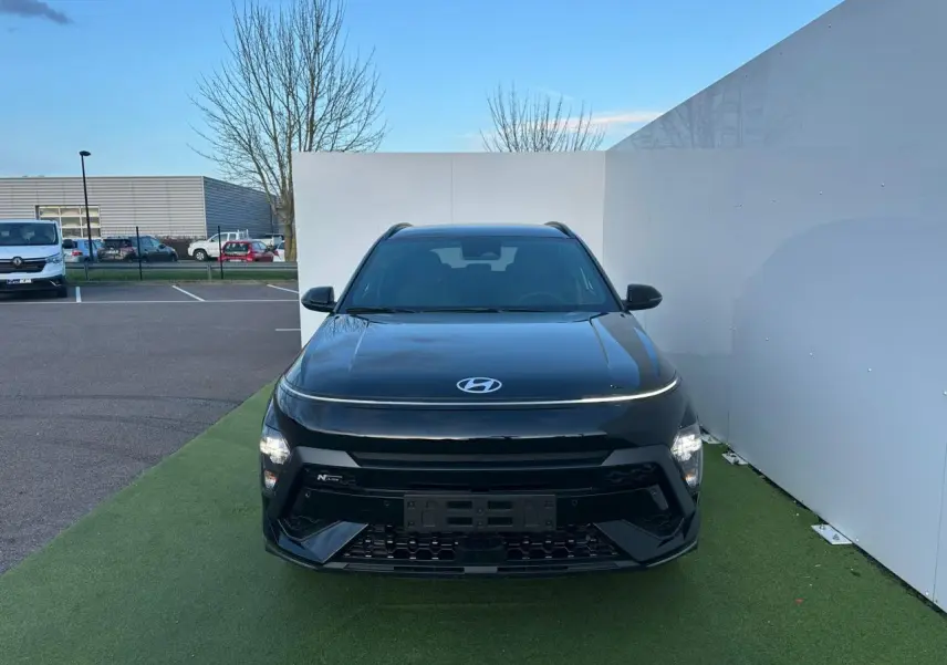 Vue frontale d'un Hyundai Kona II noir Abyss Metal avec éclairage LED et calandre N Line sur fond extérieur.