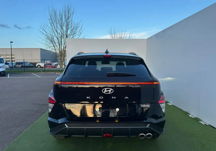 Vue arrière d'une Hyundai Kona II 1.6 Hybrid N Line noire Abyss Metal avec feux arrière LED et double sortie d'échappement.