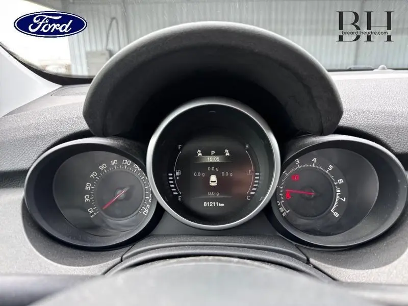 Vue rapprochée du tableau de bord d'une FIAT 500X 2017, affichage numérique central et compte-tours analogiques.