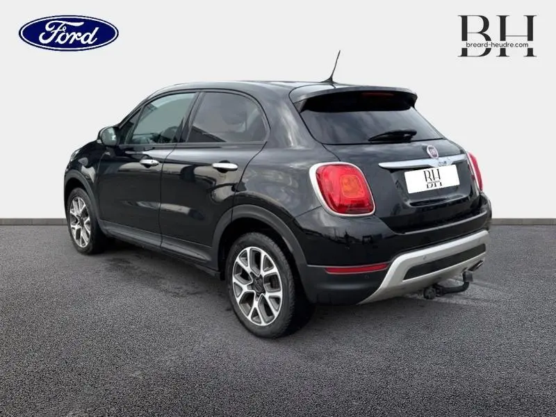Vue 3/4 arrière droite d'un FIAT 500X noir Cinéma pastel avec jantes alu et becquet arrière.