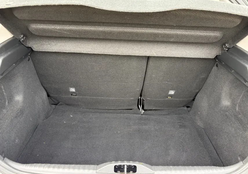 Vue intérieure du coffre noir spacieux de la Citroën C3 beige 2019, avec banquette arrière rabattue partiellement.