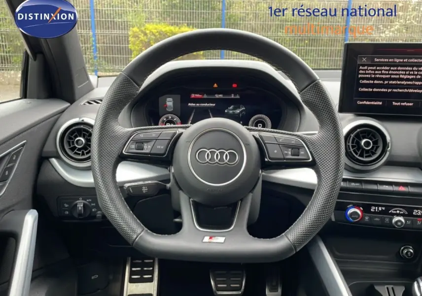 Vue intérieure centrée sur le volant perforé et le tableau de bord numérique de l'Audi Q2 S-Line noir Mito Metal.