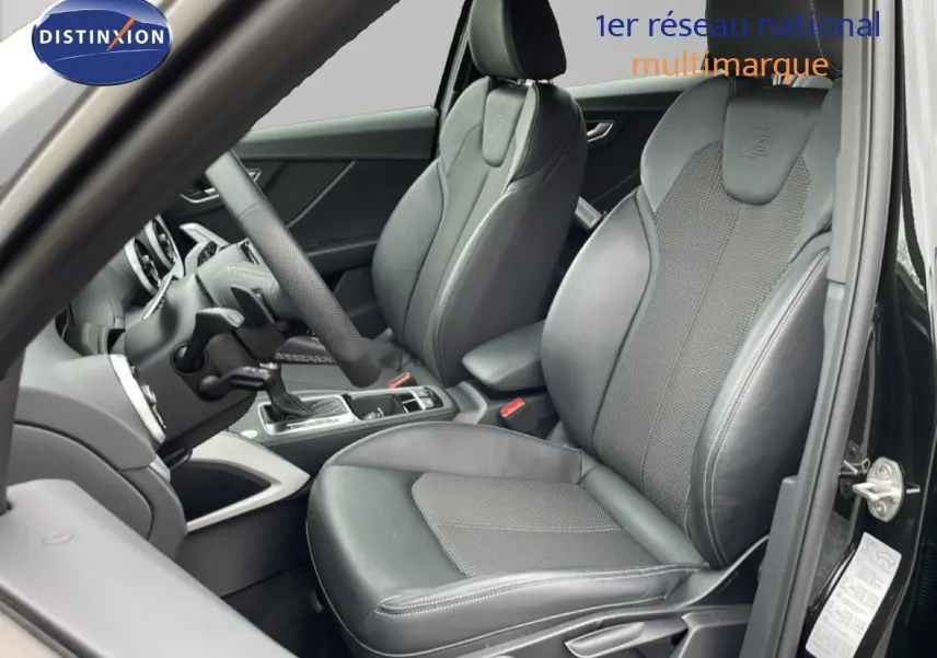 Vue intérieure côté conducteur de l'Audi Q2 noir mito metal, mettant en valeur les sièges sport en cuir avec logo S-Line embossé.