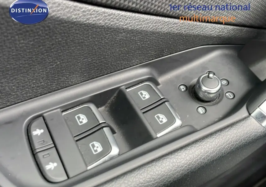 Gros plan sur les commandes des vitres et rétroviseurs côté conducteur de l'Audi Q2 noir mito metal, intérieur noir.