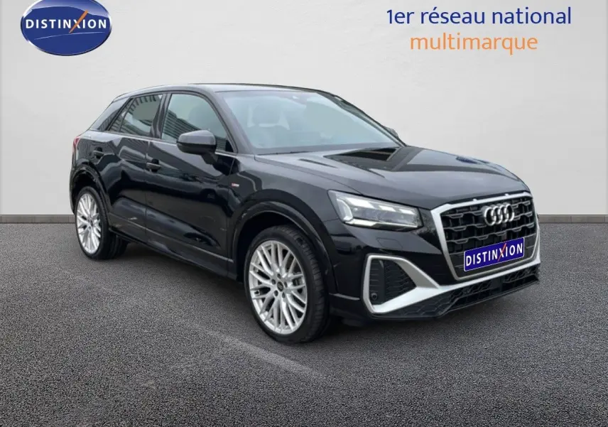 Audi Q2 noir mito metal en 3/4 avant droit, avec jantes alliage et calandre hexagonale distinctive S-Line.