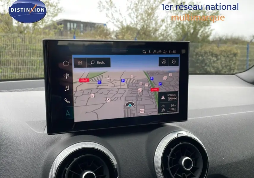 Écran tactile central affichant la navigation dans l'habitacle d'un Audi Q2 noir, vue de face sur le tableau de bord.