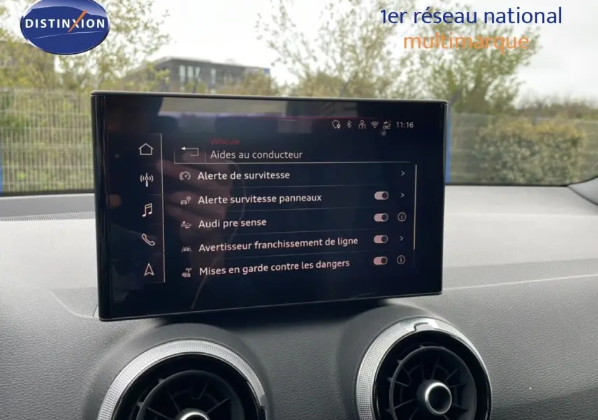 Écran tactile central affichant les aides à la conduite dans l’habitacle d’un Audi Q2 noir mito metal.