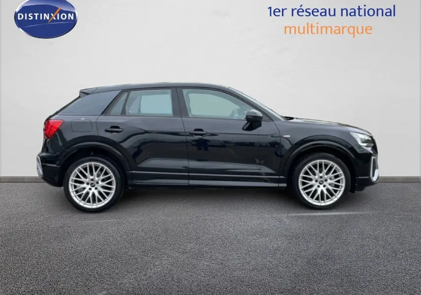 Profil côté gauche d'un Audi Q2 noir mito metal 2025 avec jantes alliage et finition S-Line visible sur fond neutre.