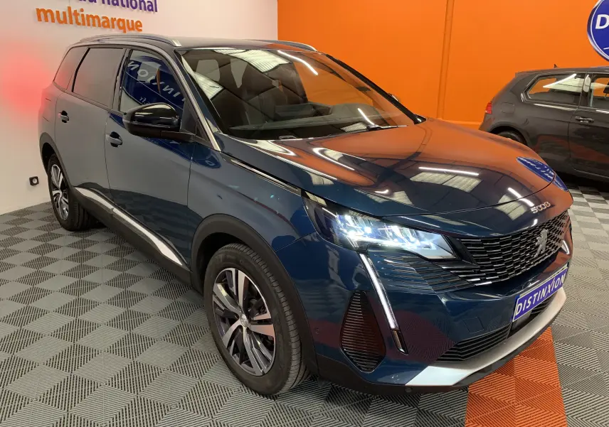 Peugeot 5008 Bleu Célèbes en 3/4 avant droit, avec phares LED allumés et calandre noire distinctive.