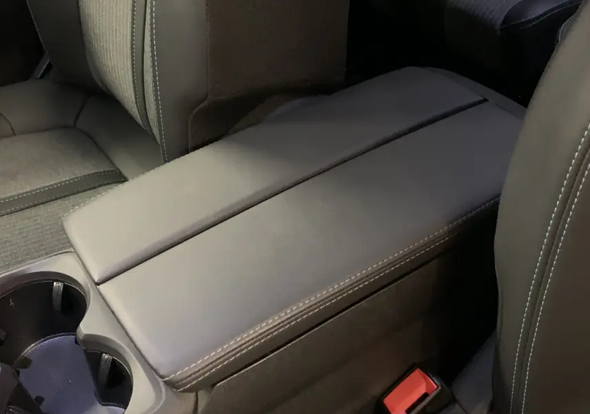 Gros plan sur l'accoudoir central en cuir noir avec surpiqûres blanches dans l'habitacle du Peugeot 5008.