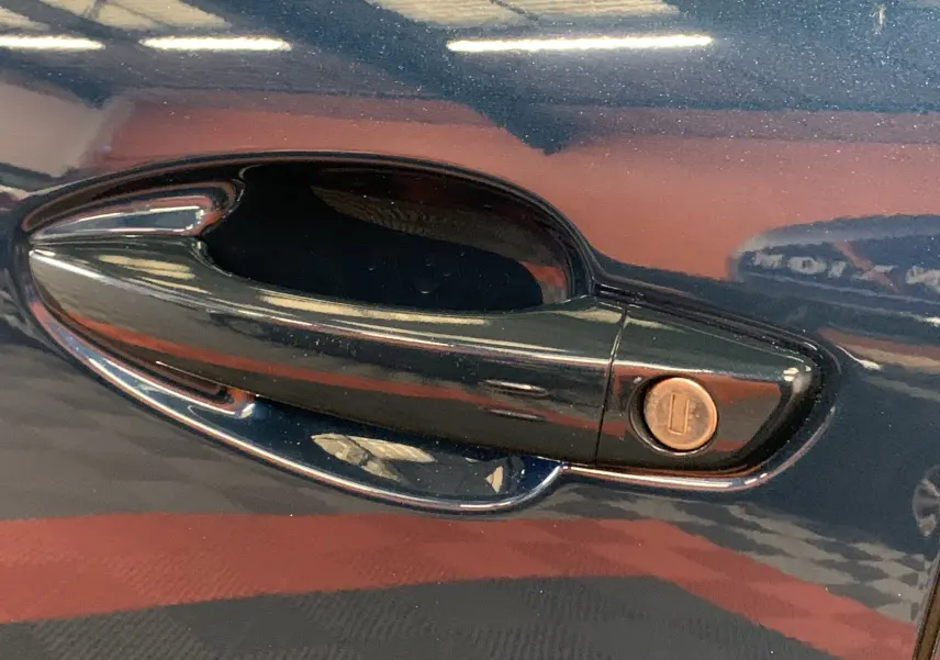Poignée de porte côté gauche en gros plan sur Peugeot 5008 bleu Célèbes avec serrure intégrée.