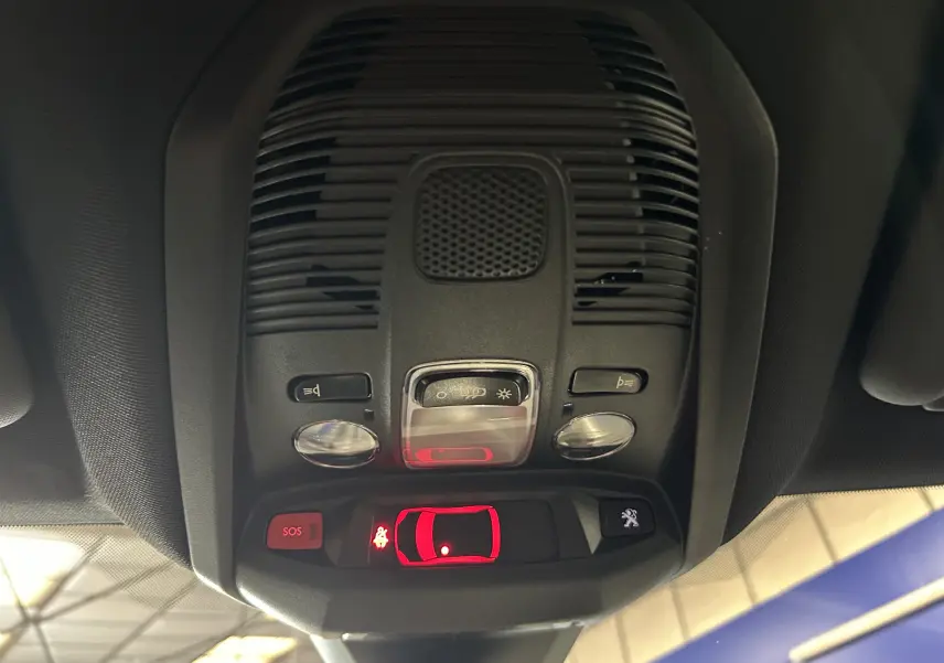 Plafonnier intérieur du Peugeot 5008 bleu, avec commandes d’éclairage et bouton SOS éclairé en rouge.