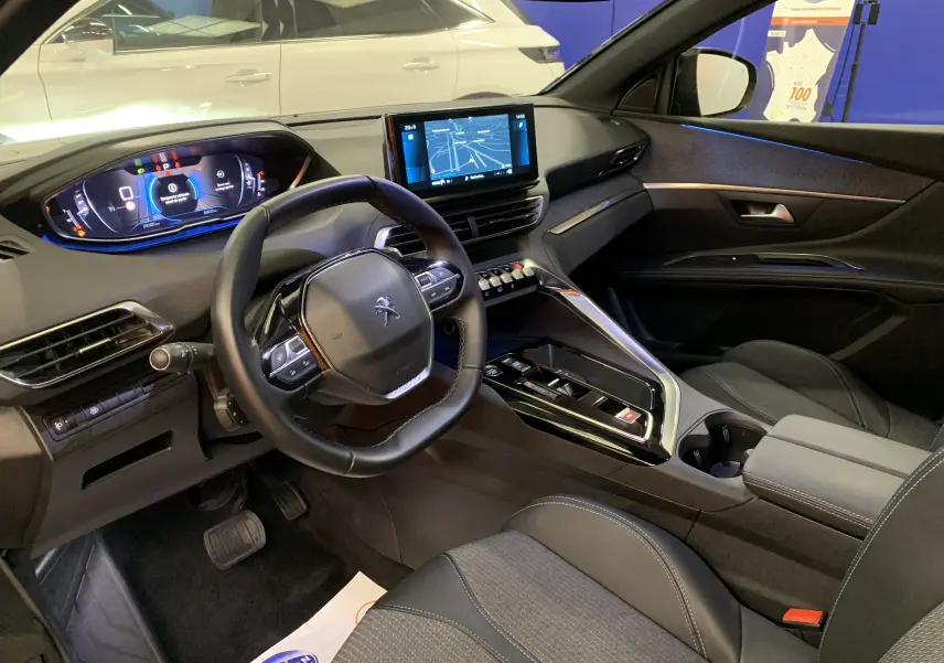 Intérieur du Peugeot 5008 II Ph.2, vue côté conducteur, tableau de bord numérique et écran central tactile visibles.