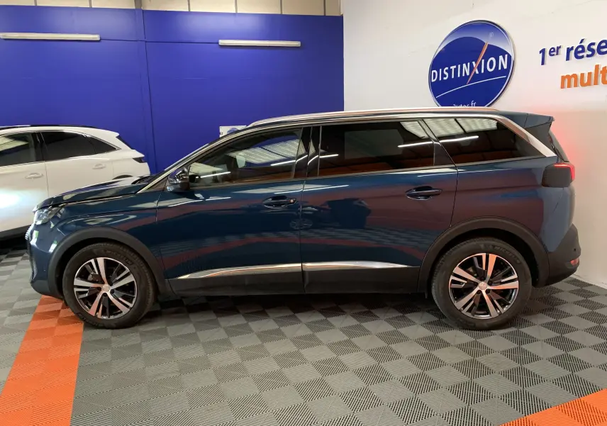 Vue de profil côté gauche d’un Peugeot 5008 Bleu Célèbes 2024 avec jantes alliage et toit contrasté argent.