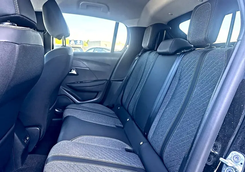 Vue intérieure côté droit sur la banquette arrière en tissu gris et noir de la Peugeot 208 1.2 100 Allure noire 2025.