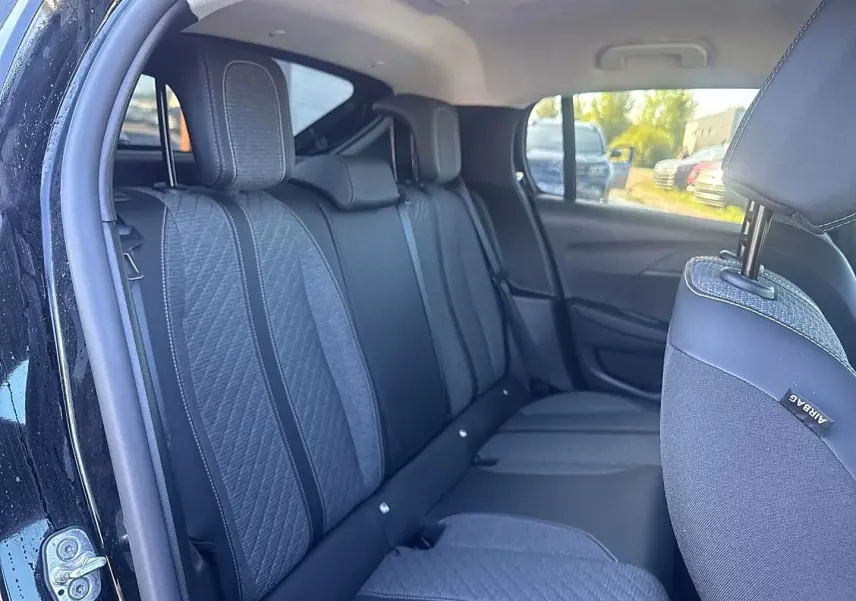 Vue intérieure côté gauche de la banquette arrière tissu gris et noir de la Peugeot 208 1.2 100 Allure noire 2025.
