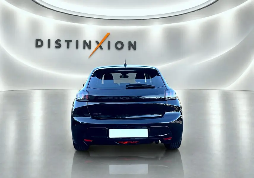 Vue arrière d'une Peugeot 208 noire 1.2 100 Allure 2025 dans un showroom lumineux avec logo Distinxion en arrière-plan.
