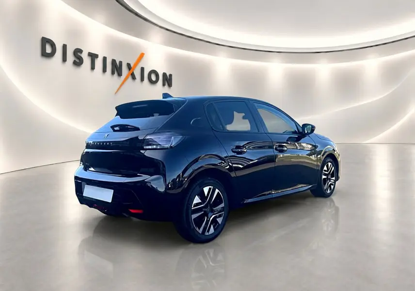 Peugeot 208 noire vue 3/4 arrière droit dans un showroom lumineux avec jantes alu et vitres teintées.
