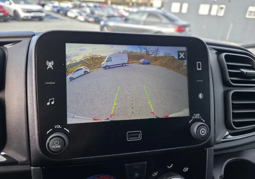 Écran central montrant la caméra de recul du Fiat Ducato Fourgon blanc, vue arrière sur parking extérieur.