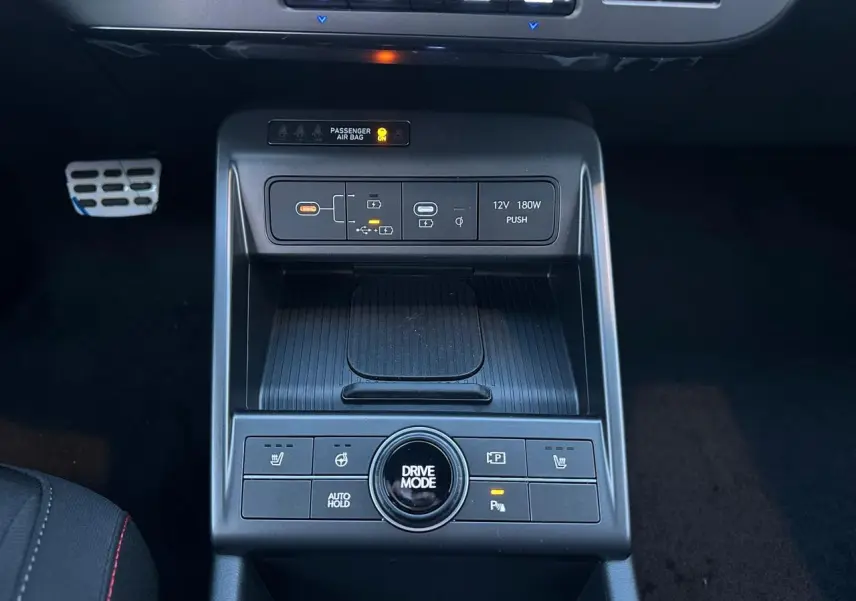 Vue intérieure centrée sur la console centrale du Hyundai Kona 2026 gris, avec commandes climatisation et ports USB-C visibles.