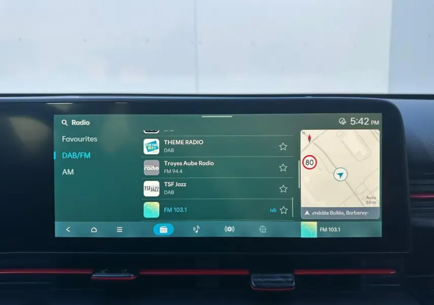Vue intérieure du tableau de bord du Hyundai Kona 2026, écran tactile multimédia affichant la radio et la navigation.