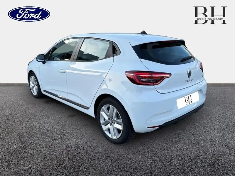 Vue 3/4 arrière droite d'une Renault Clio blanche avec vitres teintées et feux arrière LED visibles.