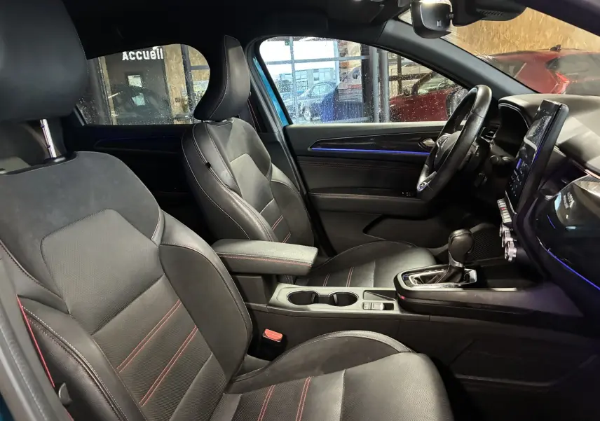 Vue intérieure côté conducteur de la Renault Arkana 1.3 TCE 140 RS-Line 2021, sièges cuir noir avec surpiqûres rouges et console centrale.