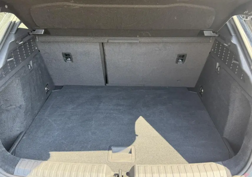 Coffre ouvert de l'Audi A3 Sportback noir Mythe, vue intérieure montrant l'espace de chargement et les fixations Top Tether.