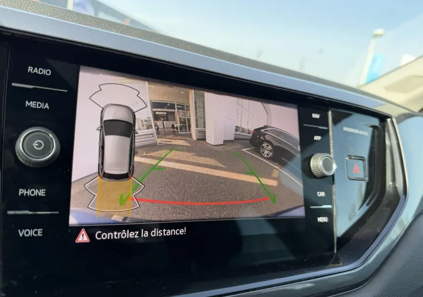 Écran tactile de la Polo 2025 montrant la caméra de recul avec vue arrière et aide au stationnement active.