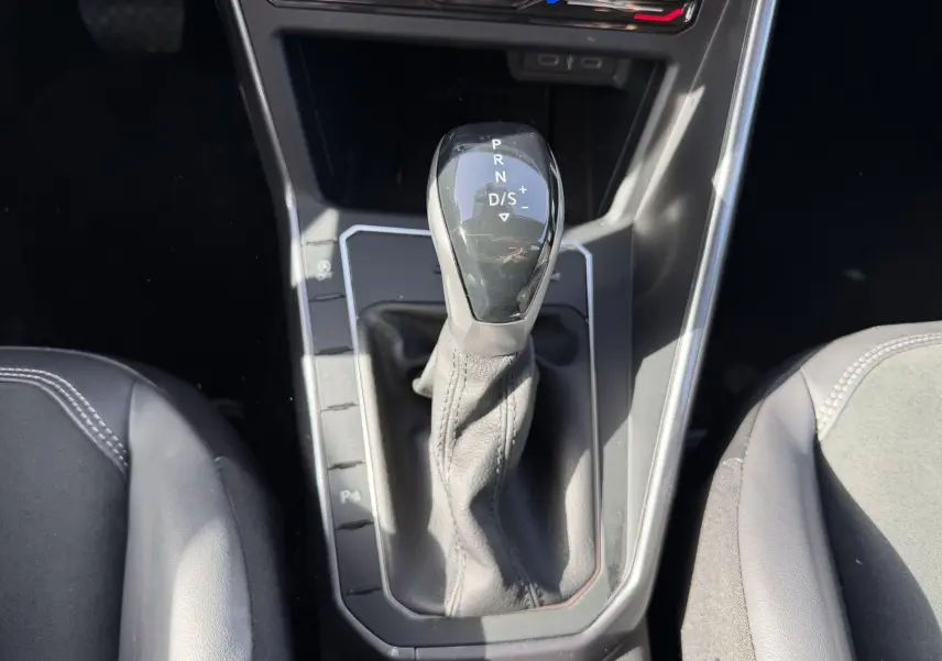 Le levier de vitesse DSG7 de la Volkswagen Polo 2025 vu de dessus avec sellerie noire autour.