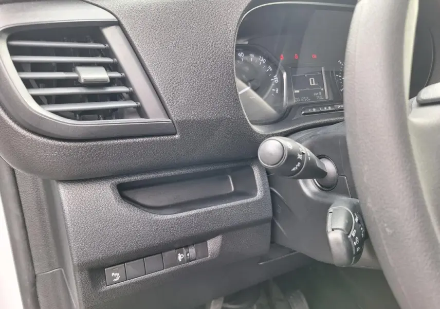 Détail de l’intérieur côté gauche du tableau de bord noir de l’Opel Vivaro 2025 avec commandes et aérateur.