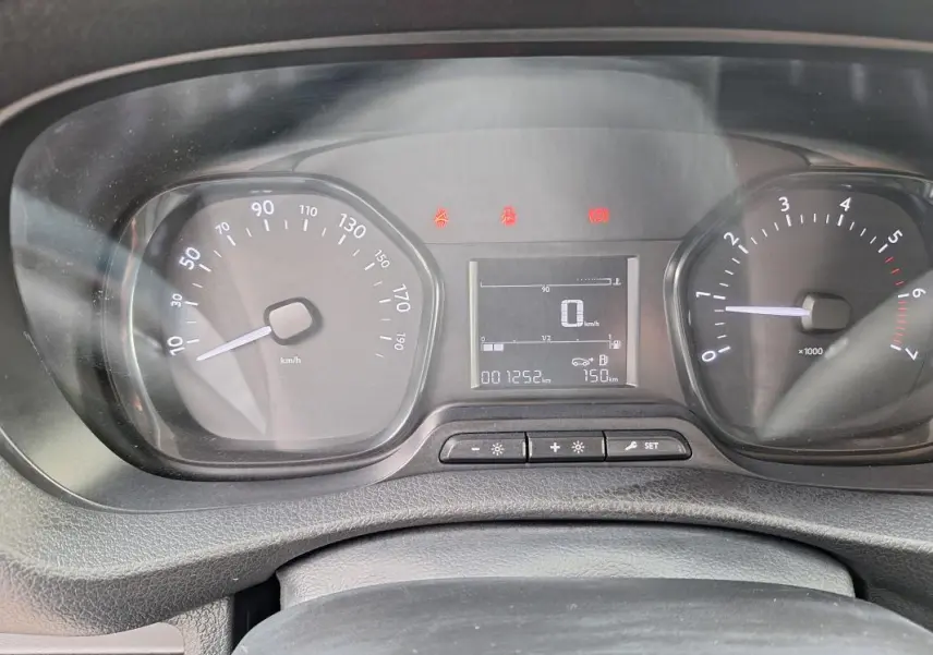 Vue rapprochée du tableau de bord du fourgon Opel Vivaro blanc, affichant compteur et écran digital.