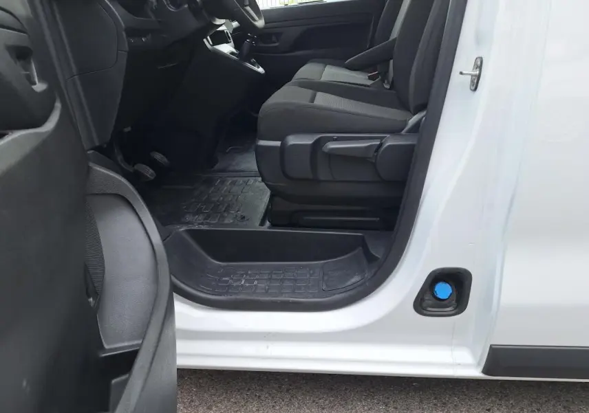 Vue intérieure côté conducteur de l’Opel Vivaro blanc 2025, montrant les sièges et le tableau de bord partiel.
